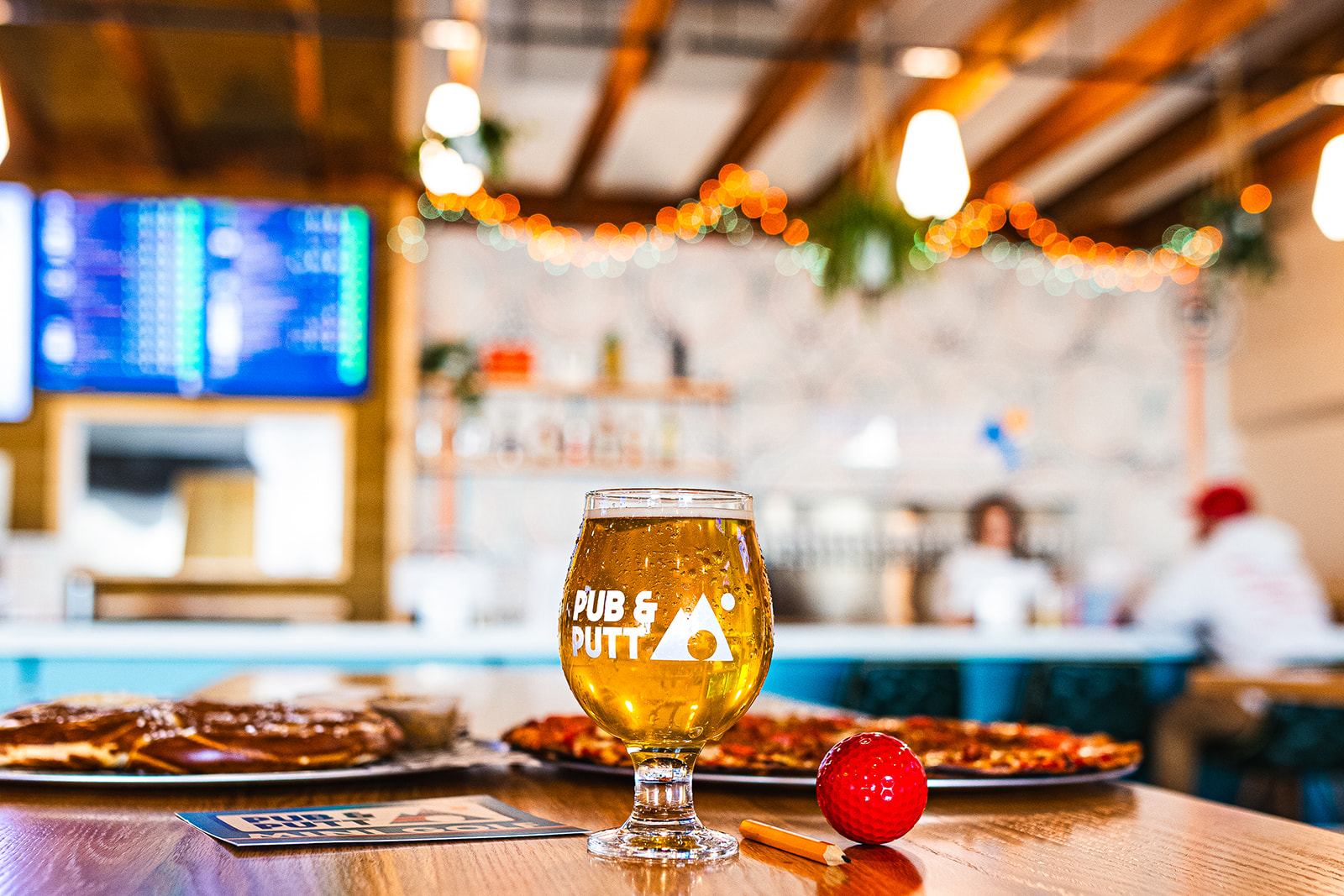 Pub & Putt interior with beer and pizza